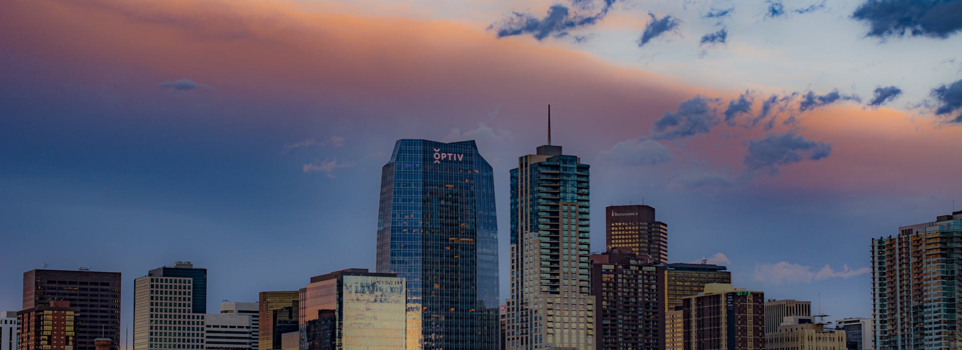 Denver skyline at dusk with Rocky Mountains